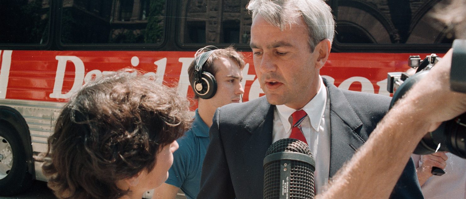 Peterson speaks to a reporter in front of the campaign bus